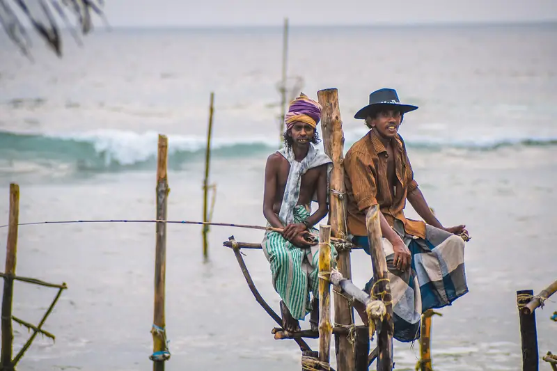 Two stilt fishermen on their poles at Ahangama