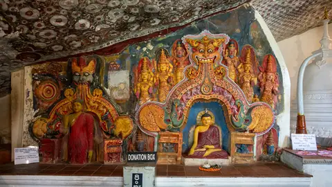 Painted statues inside the Ravana Ella Rajamaha Vihara cave temple