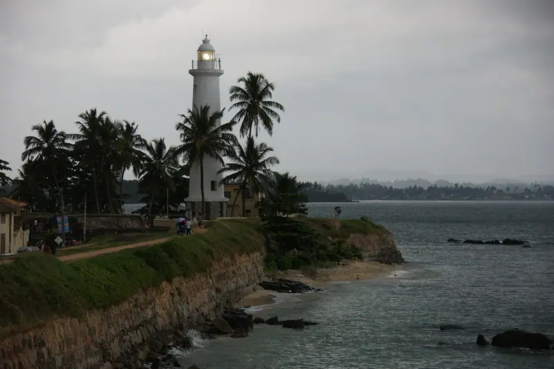 Galle lighthouse and the fort wall above the rocky shore