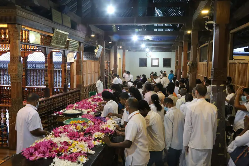 Devotees laying flower offerings inside the Temple of the Tooth