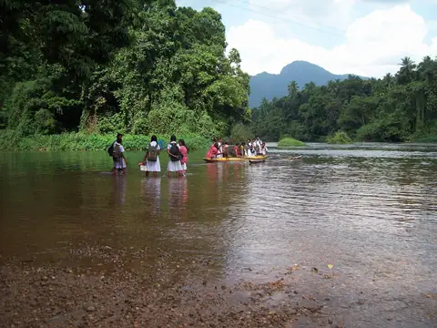 People wading across the Kelani river at Kitulgala