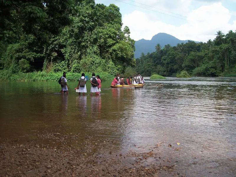 People wading across the Kelani river at Kitulgala