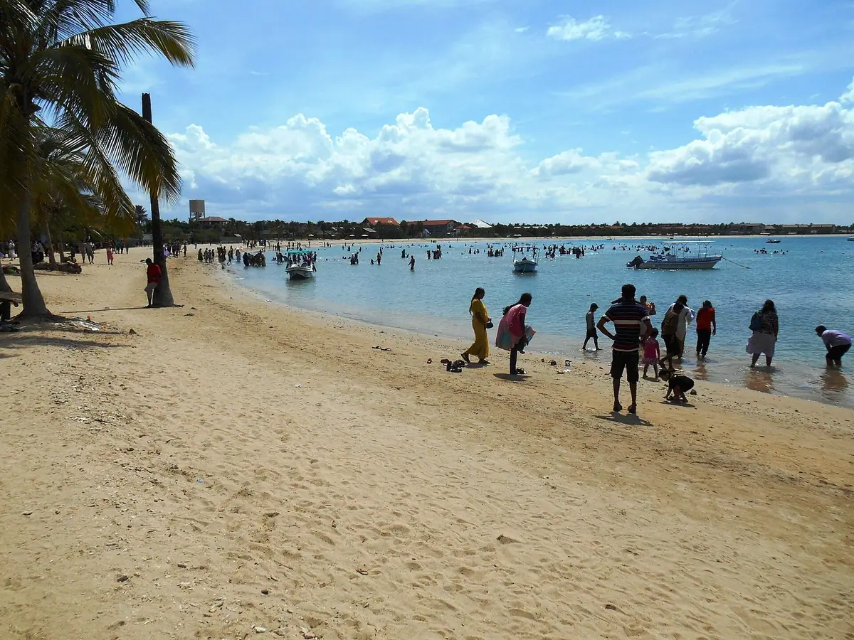 People wading in the shallow water at Pasikudah beach