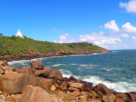 The rocky Rumassala headland with the Japanese Peace Pagoda above the sea