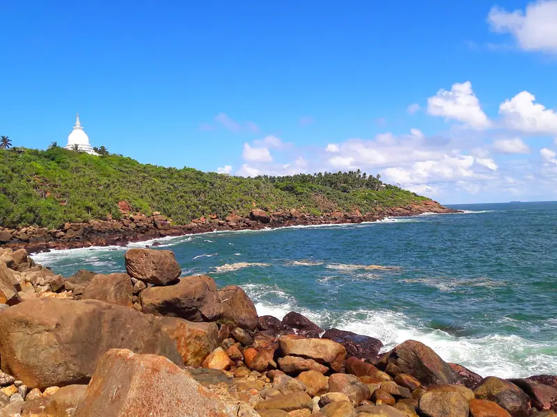 The rocky Rumassala headland with the Japanese Peace Pagoda above the sea